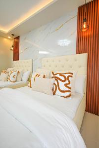 a bedroom with a large white bed with pillows at Alpine Villas at Crosswinds Tagaytay Casa de Vela in Tagaytay