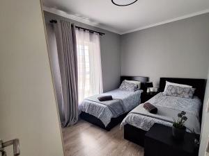 a bedroom with two beds and a window at Merve's Place - Portobelo 48 in Mossel Bay
