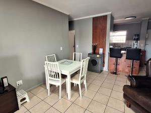 a kitchen with a table and chairs in a room at Merve's Place - Portobelo 48 in Mossel Bay