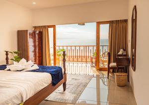 a bedroom with a bed and a balcony with the ocean at Ananas Beach Resort in Agonda