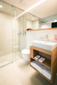 een badkamer met een wastafel, een toilet en een douche bij Raselli Sport Hotel in Poschiavo