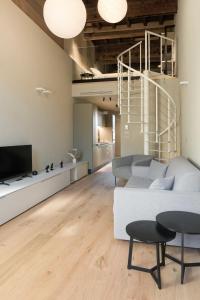 a living room with a white couch and a tv at Dimora Beggiami by Vayadù in Savigliano