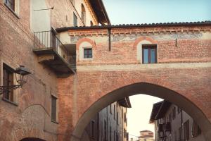 a brick building with an archway in a city at Dimora Beggiami by Vayadù in Savigliano
