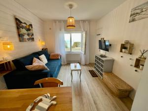 a living room with a blue couch and a table at L'Escale, Studio cosy 15m2 avec vue mer, idéal couple - Ault in Ault