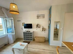 a living room with a television and a table at L'Escale, Studio cosy 15m2 avec vue mer, idéal couple - Ault in Ault