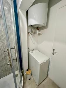 a small bathroom with a toilet and a shower at L'Escale, Studio cosy 15m2 avec vue mer, idéal couple - Ault in Ault +14 photos