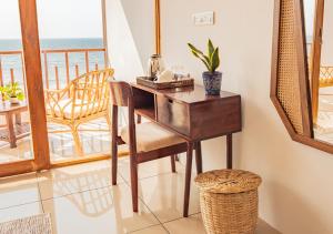 a desk and chair in a room with a balcony at Ananas Beach Resort in Agonda