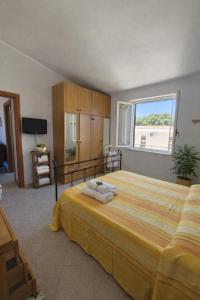a bedroom with a large bed and a window at Cala Greca Case Vacanze in Capo Rizzuto