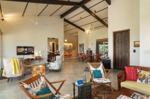 a living room with chairs and a couch at SaffronStays Vinayalam in Mahabaleshwar