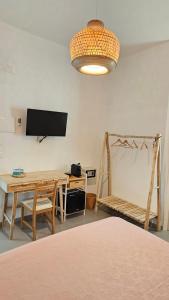a room with a table and a desk and a television at Thai Boutique rooms in Peschici