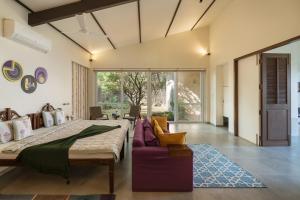 a bedroom with a large bed and a couch at SaffronStays Vinayalam in Mahabaleshwar