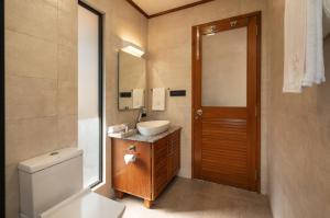 a bathroom with a toilet and a sink and a mirror at SaffronStays Vinayalam in Mahabaleshwar +49 photos