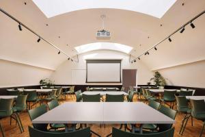 a conference room with tables and chairs and a whiteboard at Locke de Santa Joana in Lisbon