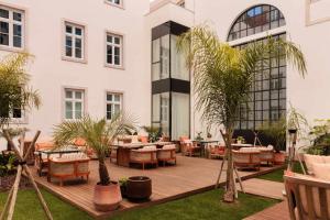 a patio with tables and chairs in front of a building at Locke de Santa Joana in Lisbon +34 photos