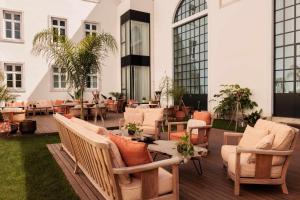 a patio with chairs and tables and a building at Locke de Santa Joana in Lisbon