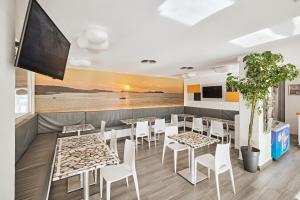 a restaurant with tables and chairs and a wall mural at Apartamentos Mar i Vent in San Antonio
