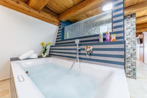 a bath tub in a bathroom with blue and white stripes at Gästehaus Hopfenperle in Spalt