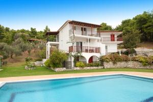 a villa with a swimming pool in front of a house at Villa Alissia in Koukounaries