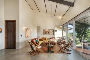 a living room with chairs and a table at SaffronStays Vinayalam in Mahabaleshwar