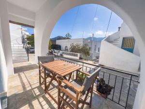 a wooden table and chairs on a balcony at Amorgona Apartments in Katapola