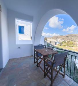 a room with a table and chairs and a balcony at Amorgona Apartments in Katapola
