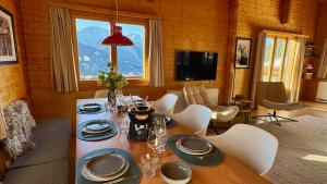 a dining room with a table and chairs and a television at Chalet Montis in Bellwald