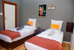 a bedroom with two beds with orange and white at Umzimkulu Hotel in Umzimkulu +4 photos