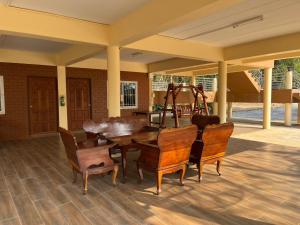 a dining room with a wooden table and chairs at baan wongsupar in Suan Phung