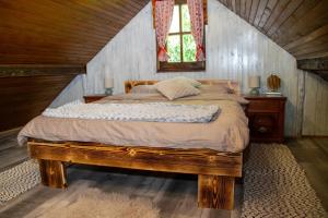 a bedroom with a bed with a wooden frame and a window at Wine Hill House Trsek with Jacuzzi in Vinagora