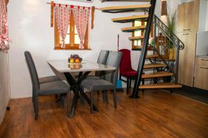 a dining room with a table and chairs and a staircase at Wine Hill House Trsek with Jacuzzi in Vinagora