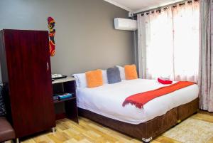 a bedroom with a bed and a window at Umzimkulu Hotel in Umzimkulu