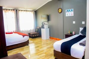 a hotel room with two beds and a chair at Umzimkulu Hotel in Umzimkulu