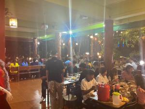 a group of people sitting at tables in a restaurant at YaithiengHill Resort ยายเที่ยงฮิลล์ รีสอร์ท in Ban Khanan Chit