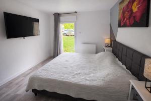 a bedroom with a bed and a flat screen tv at Domaine des Moizons, Le Laurier in Villebernier