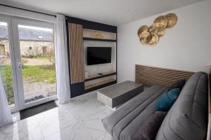a living room with a couch and a flat screen tv at Domaine des Moizons, Le Laurier in Villebernier