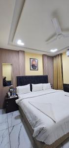 a bedroom with a large white bed in a room at Hotel Roshan in Ujjain