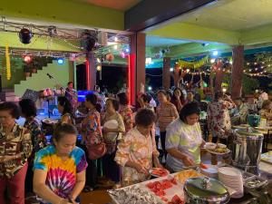 a group of people standing around a buffet line with food at YaithiengHill Resort ยายเที่ยงฮิลล์ รีสอร์ท in Ban Khanan Chit