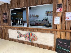 a restaurant with a bar with a butterfly sign at Camping Le Roc in Vairé