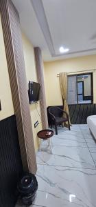 a living room with a couch and a chair in a room at Hotel Roshan in Ujjain