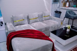 a living room with a couch with a red blanket at Hadraj Clocktower Apartment1 in Arusha