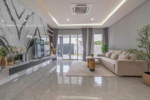 a living room with a couch and a table at 63 Jomtien Beach villa วิลล่าใกล้หาดจอมเทียน 這棟別墅距離海灘不遠 in Jomtien Beach