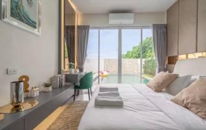a bedroom with a white bed and a table and a window at 63 Jomtien Beach villa วิลล่าใกล้หาดจอมเทียน 這棟別墅距離海灘不遠 in Jomtien Beach +45 photos