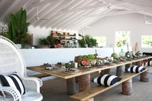 a long wooden table with plates of food on it at The Moso in Moso Island
