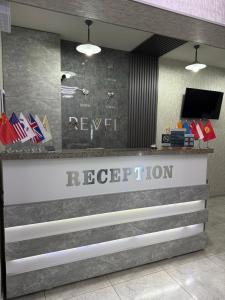a reception desk in a lobby with the reynvelt reputation at ReveL HoteL in Tashkent