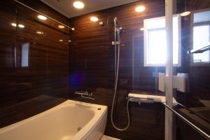 a bathroom with a bath tub and a window at NIYS apartments 04 type in Tokyo +25 photos