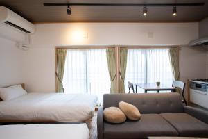 a bedroom with a bed and a couch and a table at NIYS apartments 04 type in Tokyo