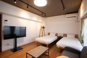 a living room with two beds and a flat screen tv at NIYS apartments 04 type in Tokyo