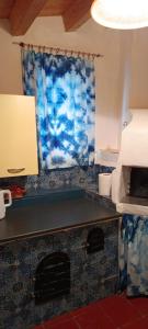 a room with a fireplace with a blue curtain at Casa Bainsizza in Isnello +7 photos