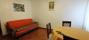 a living room with an orange couch and a table at Casa Bainsizza in Isnello
