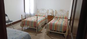 a bedroom with two twin beds and a lamp at Casa Bainsizza in Isnello